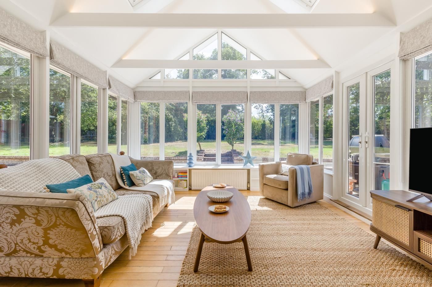 A spacious living room with a large window, a sofa, a chair, and a coffee table.