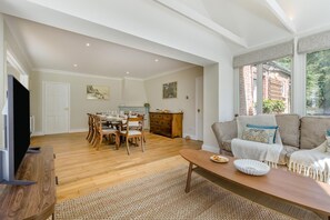 Ein geräumiger Wohnbereich mit Esstisch, Sofas und Fernseher.