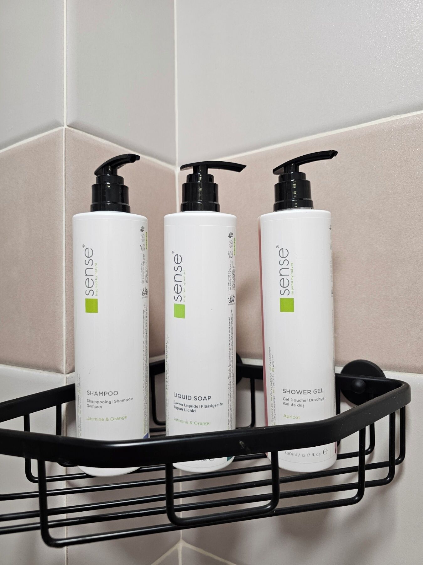 Trois flacons de produits de toilette de la marque Sense, présentés dans un panier en métal noir.