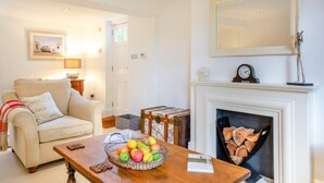 A living room with a fireplace, a sofa, a coffee table with fruit, and a painting on the wall. - 2 Bed in Matfield (oc-s42710) (Matfield)