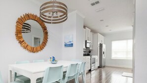 Una cocina moderna con gabinetes blancos, un microondas y un refrigerador.