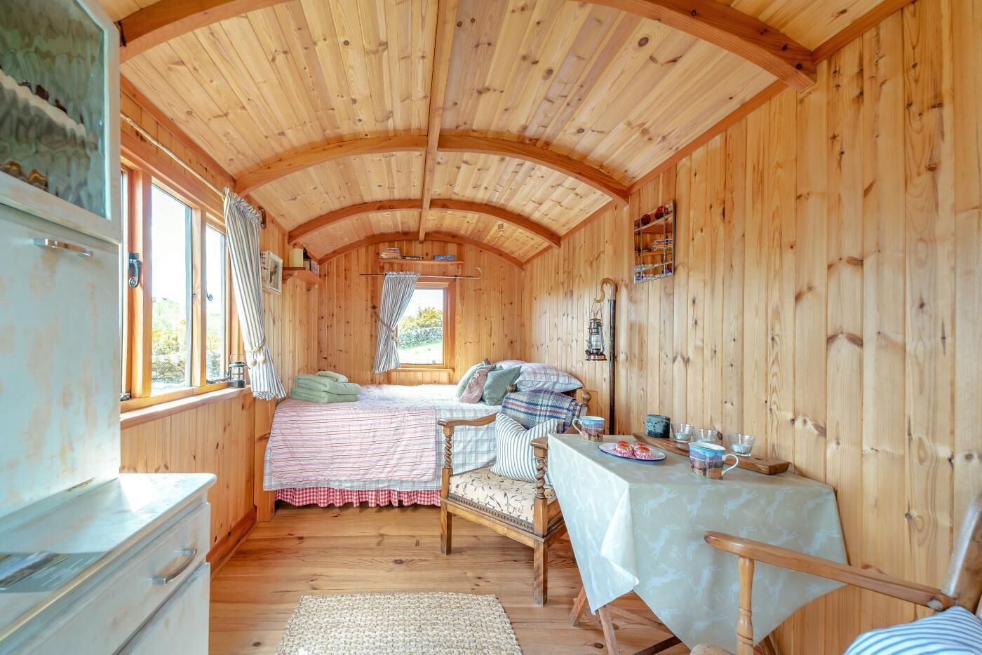 A cozy cabin-style room with a bed, a table, and a window.
