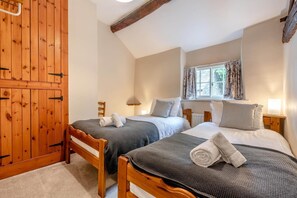 A bedroom with two single beds, a wooden wardrobe, and a window with curtains. - 4 Bed in Bassenthwaite (oc-m40272) (Wythop)