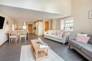 Ein modernes Wohnzimmer mit Essbereich, einer Couch und einem Couchtisch.