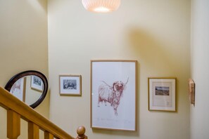 A staircase with a wooden handrail, a mirror, and framed artwork on the wall. - 3 Bed in Coldstream (oc-c39085) (Coldstream)