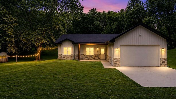 A single-story house with a garage, a front porch, and a well-maintained lawn. - Ranch Style Home_Easy Access to HWY_Sleeps 6 (Avondale)
