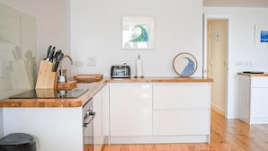 Una cocina moderna con encimera de madera, armarios blancos y una isla central.