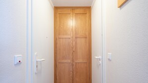 Eine Holztür im Durchgang mit Lichtschalter an der Wand.