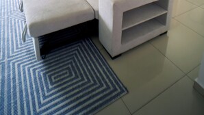Una sala moderna con un sofá, una mesa de centro y una mesita auxiliar.
