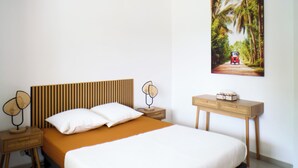 Un dormitorio con cama, mesitas de noche, lámpara, un cuadro en la pared y una lámpara de techo.