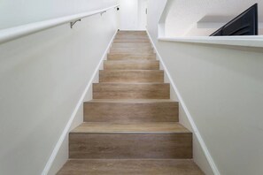 Eine Treppe mit Holzbodenstufen und weißen Wänden.