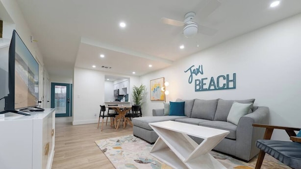 Uma sala de estar moderna com um sofá, mesa de centro e uma parede com o texto 'Jack Beach'.