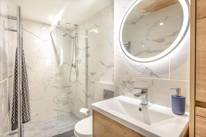 A modern bathroom with a glass shower enclosure, a white sink with a marble countertop, and a wooden vanity. - 2 Bed in Lynton (oc-v42649) (Lynmouth)