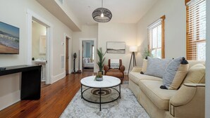 Ett vardagsrum med en soffa, ett soffbord och en tavla på väggen.