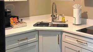 Une cuisine équipée d’un four à micro-ondes, d’un évier et de placards.