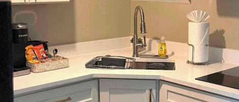 A kitchen with a microwave, sink, and cabinets.