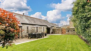 A stone building with a tiled roof, a grassy yard, and a wooden gate. - 3 Bed in Duloe (oc-h27526) (Duloe)