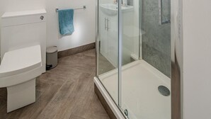 Une salle de bain moderne avec une douche à parois de verre, des toilettes et un lavabo.