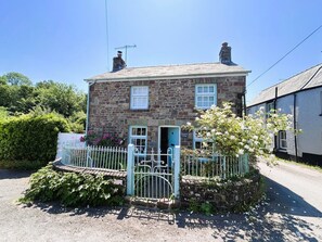 A stone house with a blue door, a white fence, and a sign that reads 'Bridgewood Cottage.' - 2 Bed in Llangynidr (oc-b42697) (Llangynidr)