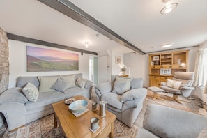 A cozy living room with two sofas, a wooden coffee table, and a bookshelf. - 2 Bed in Llangynidr (oc-b42697) (Llangynidr)