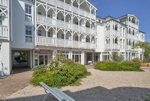 A white building with multiple balconies and a gravel courtyard. - Urlaub auf Rugen mit Ahoi-vorteil (Sellin)
