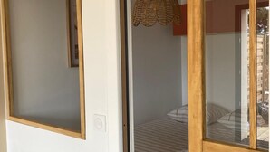 Un dormitorio con cama, lámpara colgante y marco de puerta de madera.