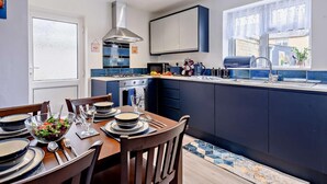 Une cuisine moderne avec un coin repas, une cuisinière intégrée et une fenêtre offrant une vue agréable.