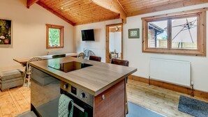 Een keuken met een houten plafond, een groot raam en een ingebouwde kookplaat.