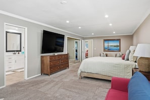 A bedroom with a large bed, a television, a dresser, and a painting on the wall. - Remodeled 4BR Retreat - FirePit + Basketball Court (Atascadero)