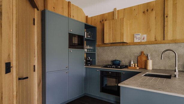 A kitchen with wooden cabinets, a stove, and a sink. - 2 Bed in Grasmere (oc-lr246) (Penrith)