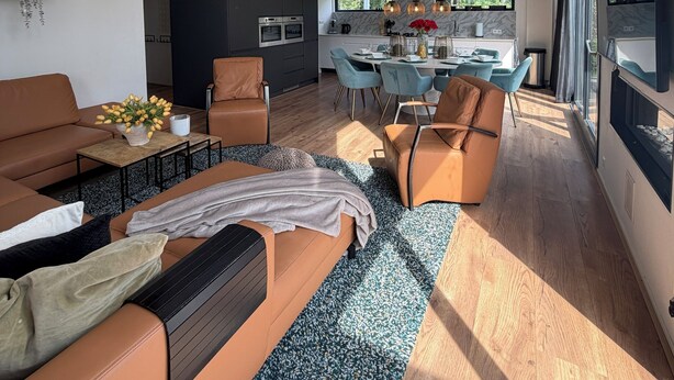 Un espace de vie moderne comprenant un canapé, une table basse et un coin repas avec des chaises.