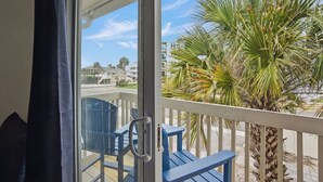 Een balkon met uitzicht op een palmboom en gebouwen.