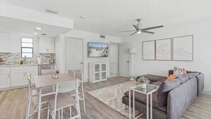 Een modern appartement met een keuken, eetgedeelte, woonkamer en een plafondventilator.