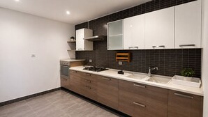 A modern kitchen with a double sink, a stove, and a microwave. - Luxury Apartment in Ain Zaghouan (Ain Zaghouan)