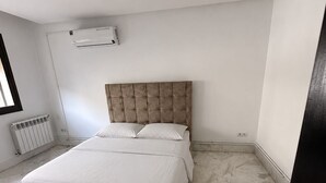 A bedroom with a bed, a radiator, and a door. - Luxury Apartment in Ain Zaghouan (Ain Zaghouan)