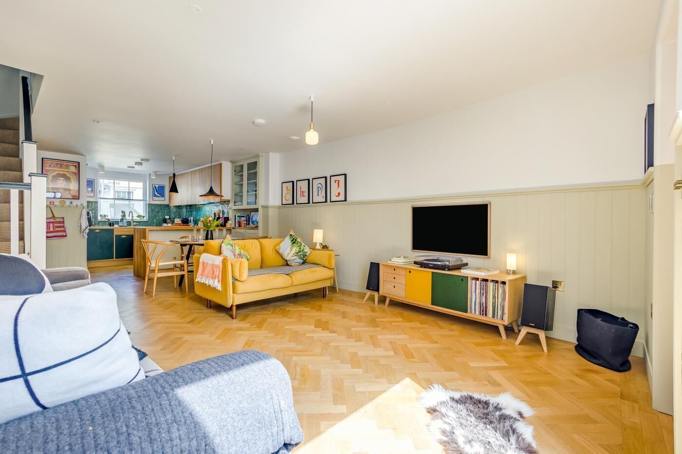 A living room with a sofa, a television, and a bookshelf.