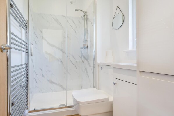 A bathroom with a glass-enclosed shower, a toilet, and a vanity with drawers. - 1 Bed in Dalry (oc-b43281) (Dalry)