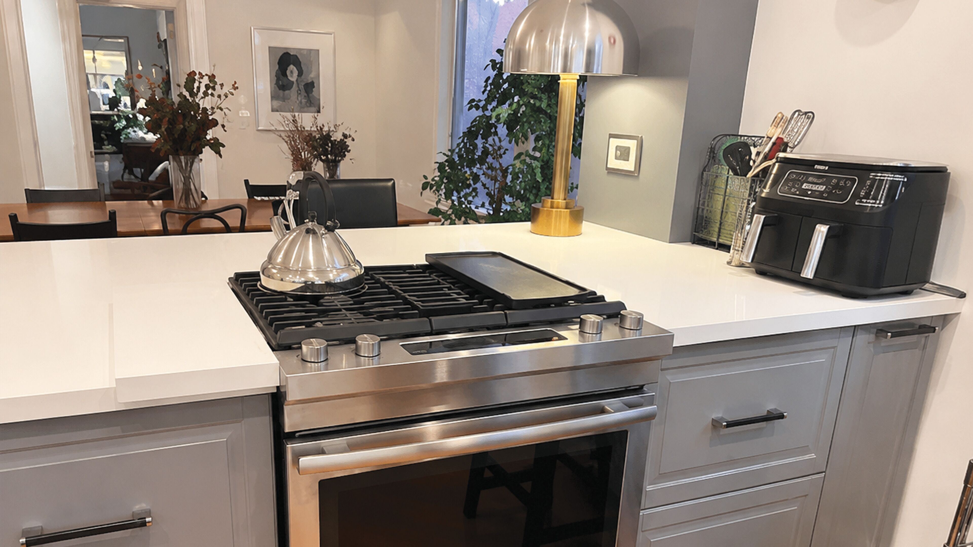 A modern kitchen with a built-in stove, oven, and a coffee maker on the counter.