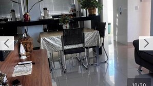 A dining area with a table, chairs, and a potted plant.