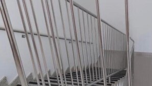 A metal staircase with a handrail, leading to a landing.