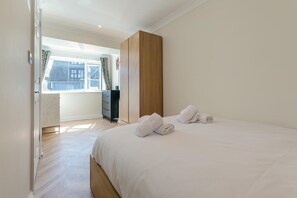 Ett hotellrum med en säng, en garderob, en byrå och utsikt över omgivningarna.
