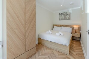 A bedroom with a bed, a nightstand, a lamp, and a wall-mounted artwork. - 1 Bed in St. Ives (oc-l43758) (St Ives)