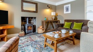 A cozy living room with a fireplace, a sofa, a coffee table, and a television. - 2 Bed in Strath (oc-s44223) (Gairloch)