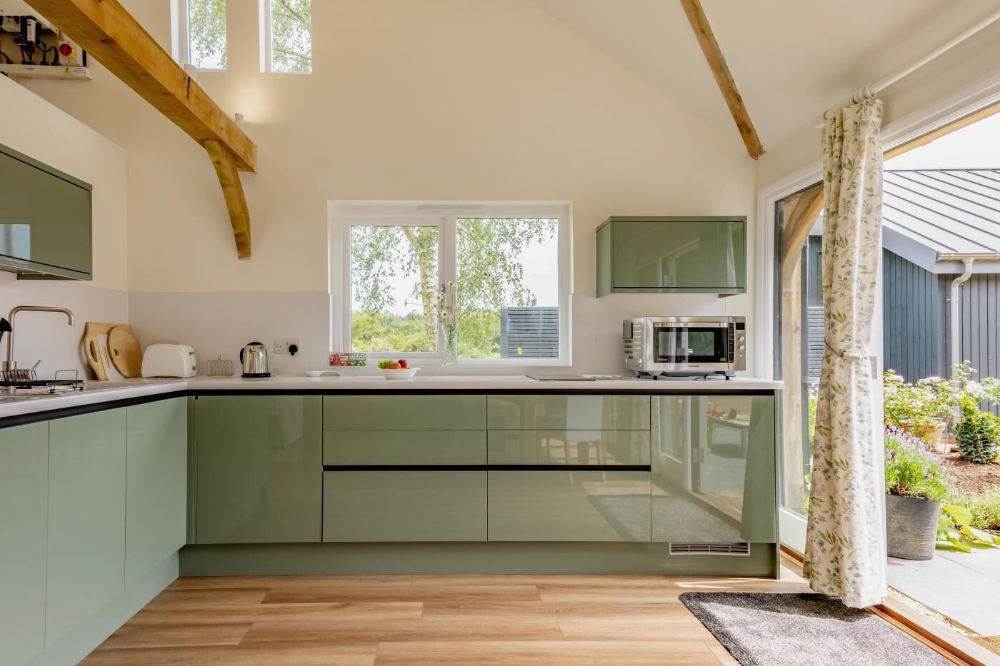 Een moderne keuken met een groot raam, een magnetron en een inbouwoven.