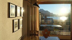 Ein Zimmer mit Tisch, Stühlen, einer Lampe und gerahmten Bildern an der Wand.