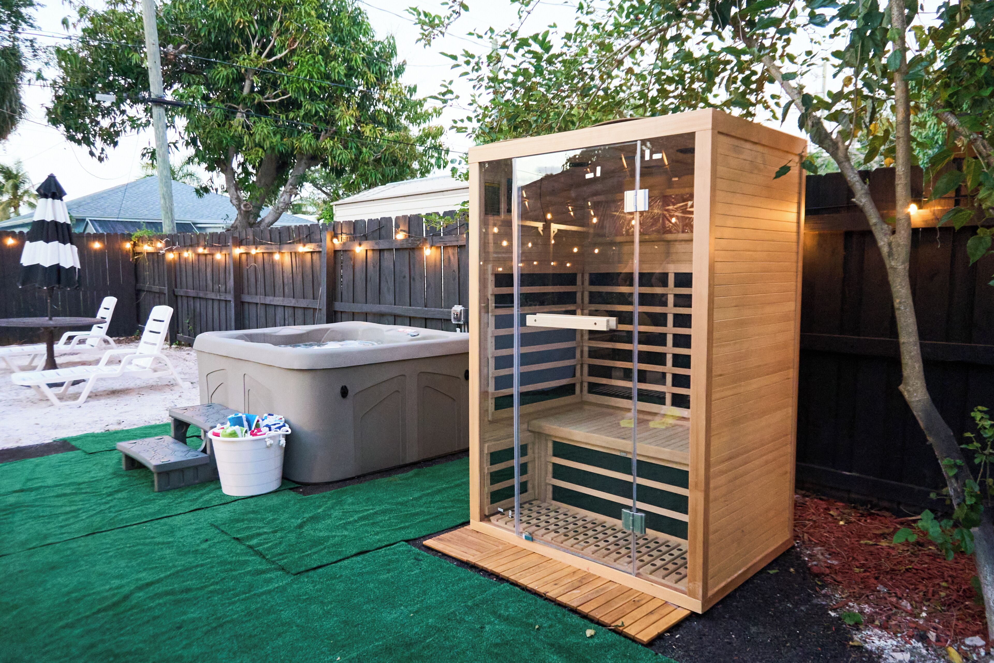 Eine holzähnliche Wellness-Anlage mit Bank und Whirlpool in einem Garten.