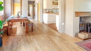 Ein geräumiges Interieur mit einem Holztisch, einem Kamin und einer Küchenzeile.