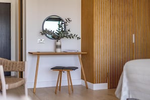 A room with a wooden desk, a small stool, a mirror, and a plant. - 7 Bed in Newquay (oc-s42829) (Newquay)