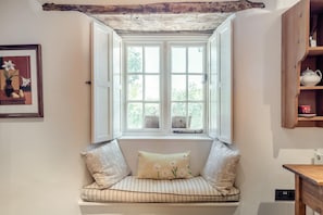 A cozy room with a window seat, a framed picture, and a wooden shelf. - 2 Bed in Yealmpton (oc-o42800) (Yealmpton)