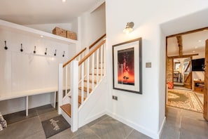 A hallway with a staircase, a coat rack, a welcome mat, and a framed picture on the wall. - 2 Bed in Yealmpton (oc-o42800) (Yealmpton)